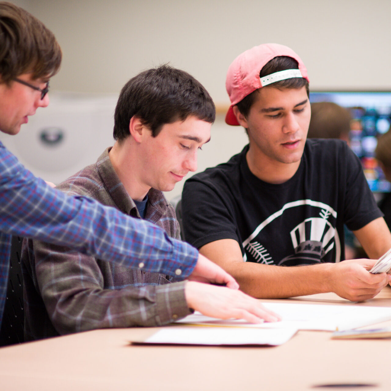 Three students working together on a project in class.