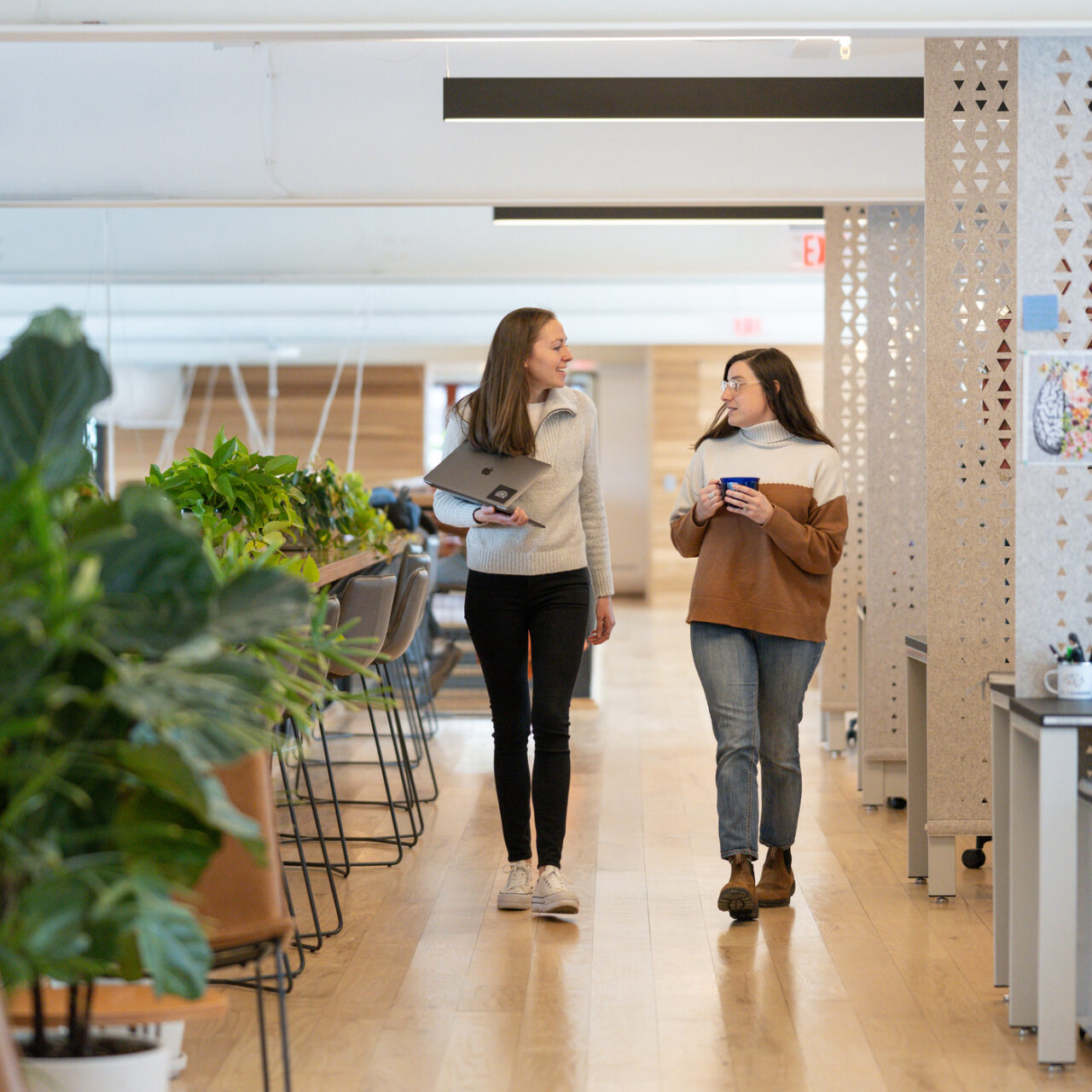 Two college students walking in office building