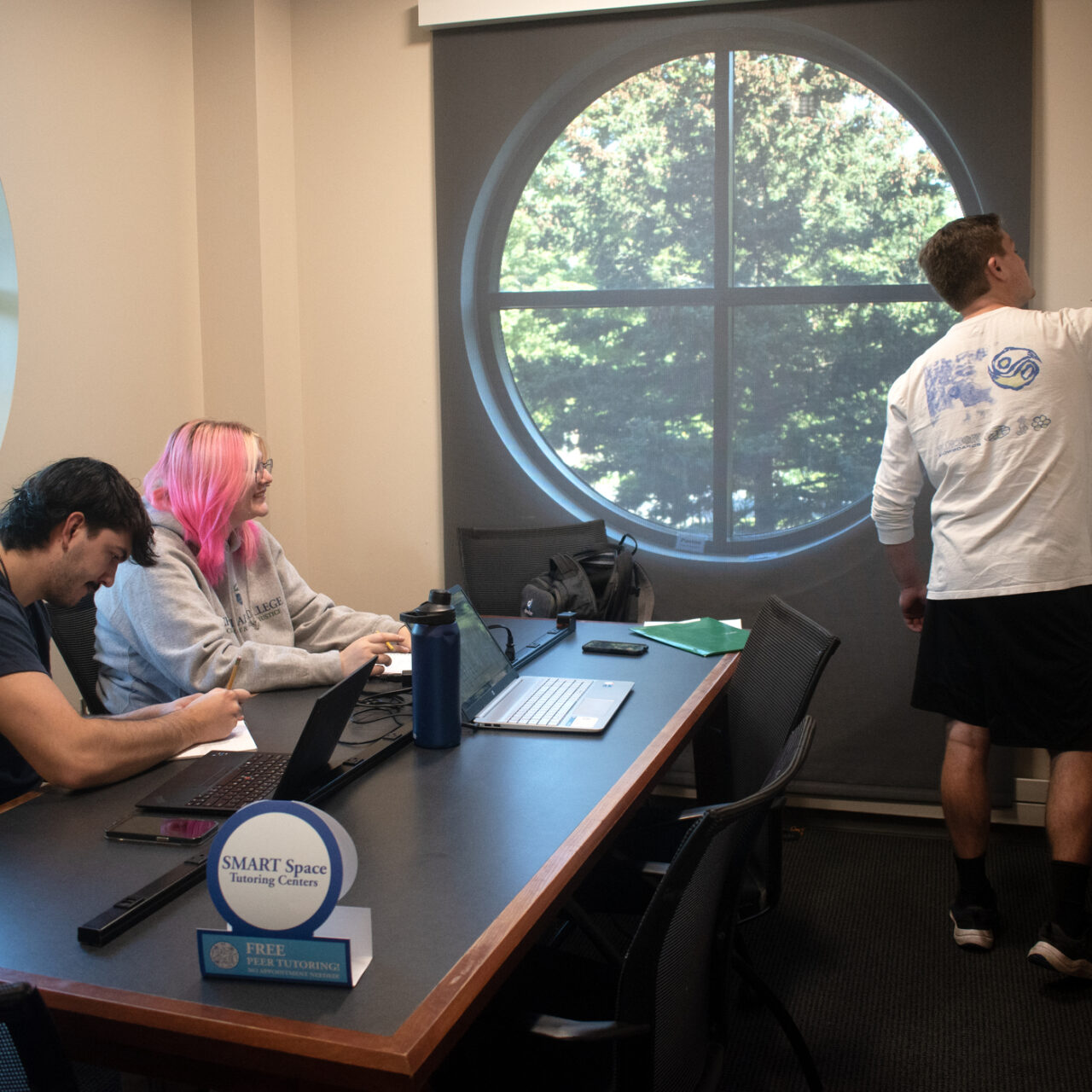 Student tutoring two other students at the Smart Space