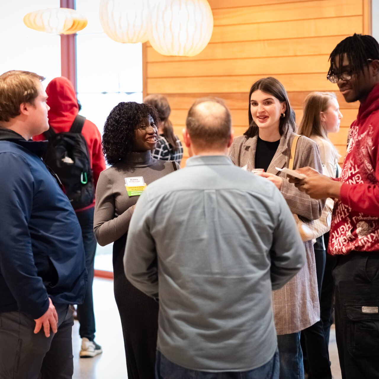 A group of people chatting at an off campus networking event. 