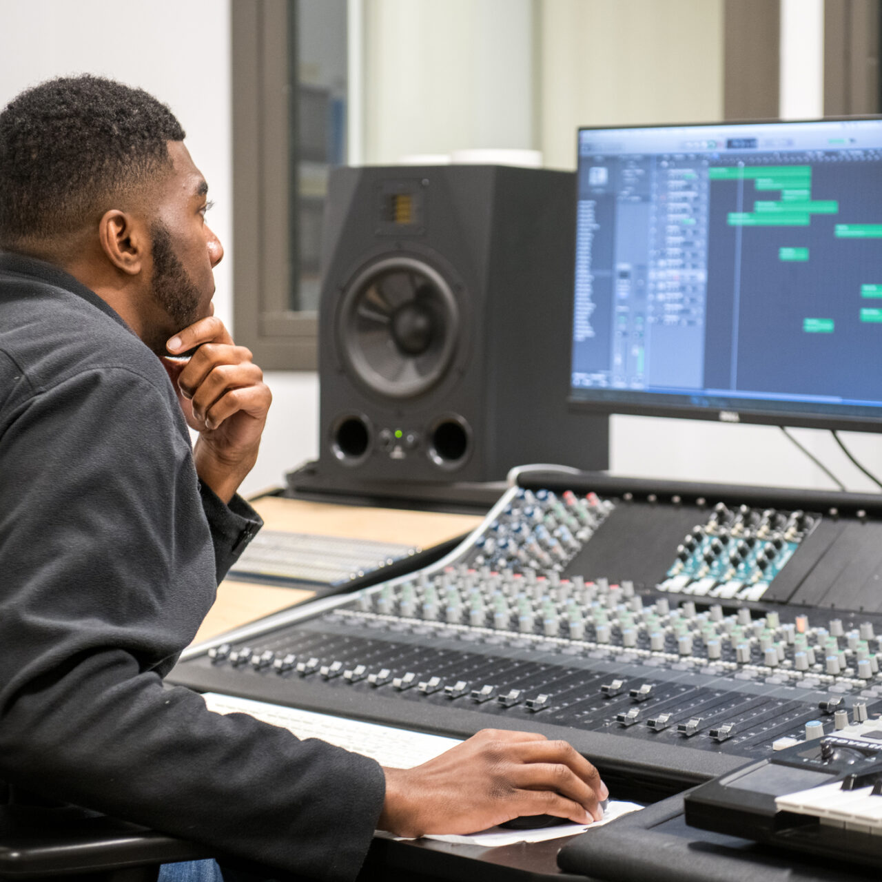 Student working on a soundtrack in a music studio.